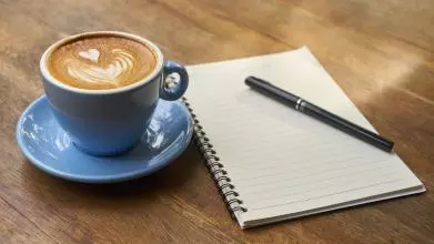 Writing notes and drinking coffee